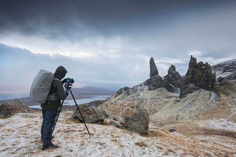 Photographer in coat photographing landscape