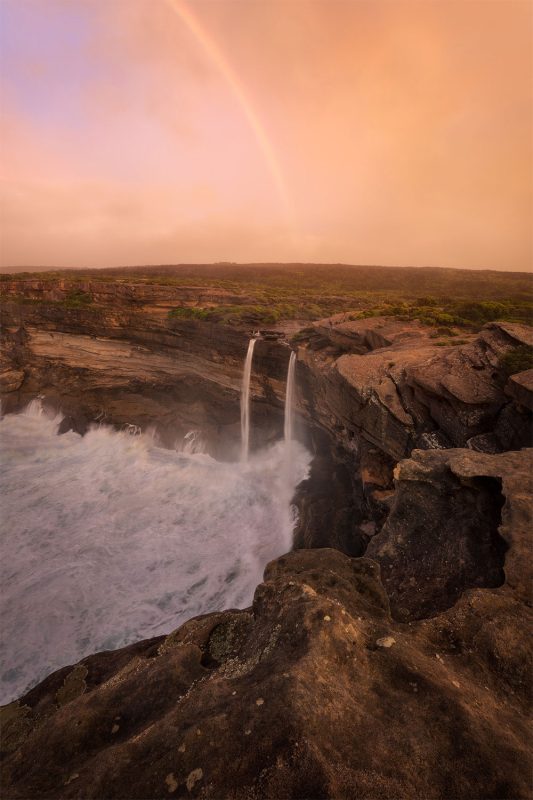 rainbow over waterfall photograph